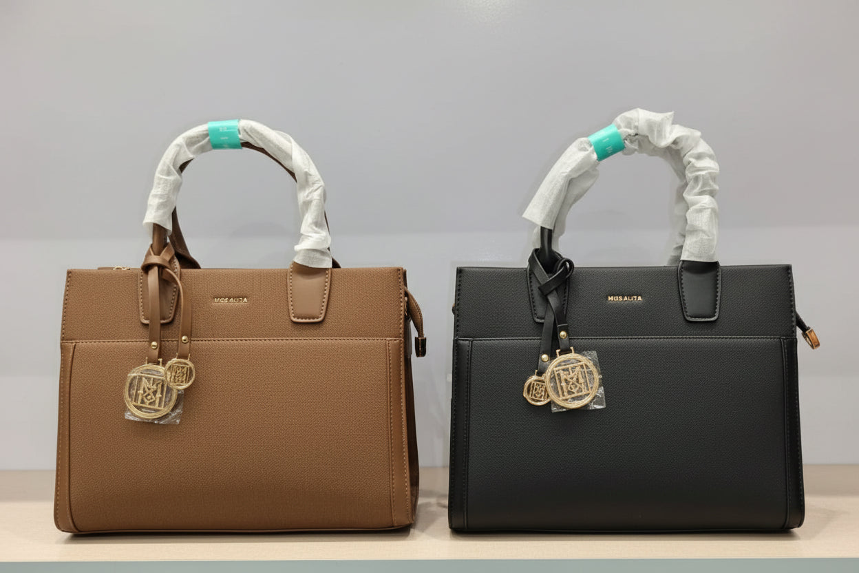 Two Versace handbags displayed side by side on a shelf, one in brown and one in black, both with white protective wrapping on the handles and gold-tone hanging charms.